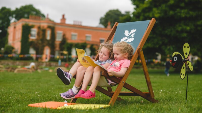 Children sat on a deckchair outside Killerton House