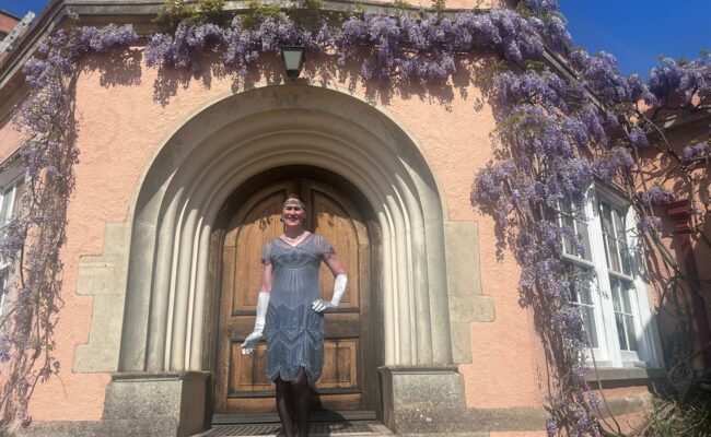 A woman dressed in 1920s outfit outside Killerton house