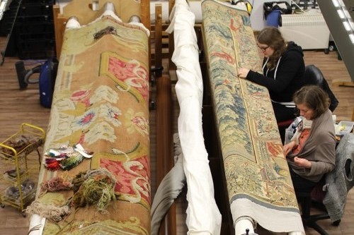 Two people conserving a large carpet