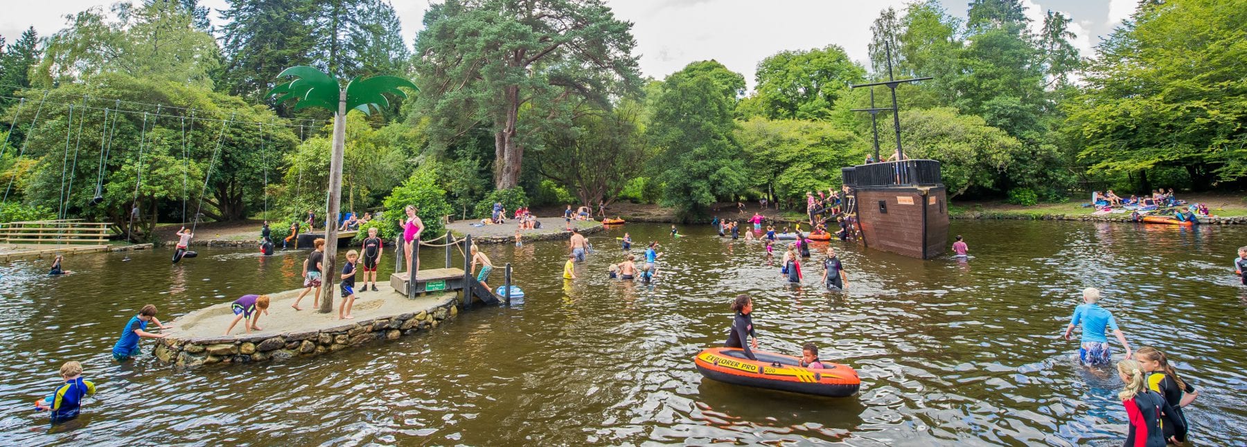 Children playing on the ships and in the water at River Dart