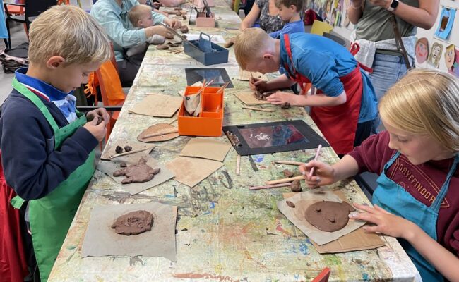 Photograph showing families creating artwork from clay