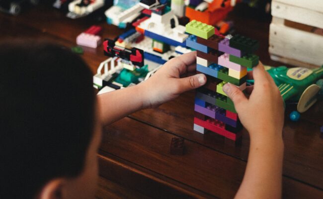 a child playing with a block of lego bricks