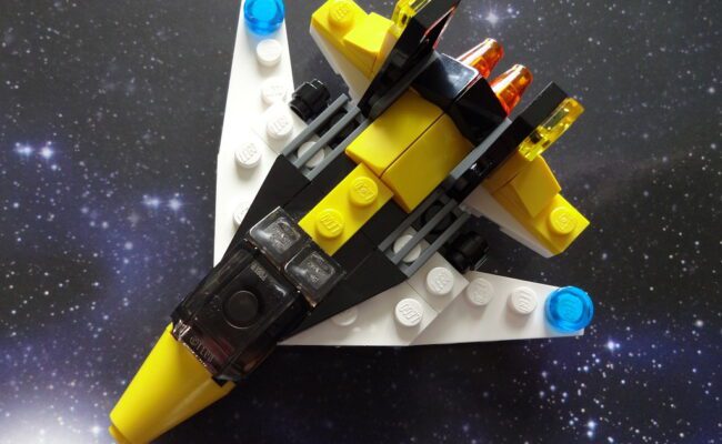 a small space ship made of black and yellow lego