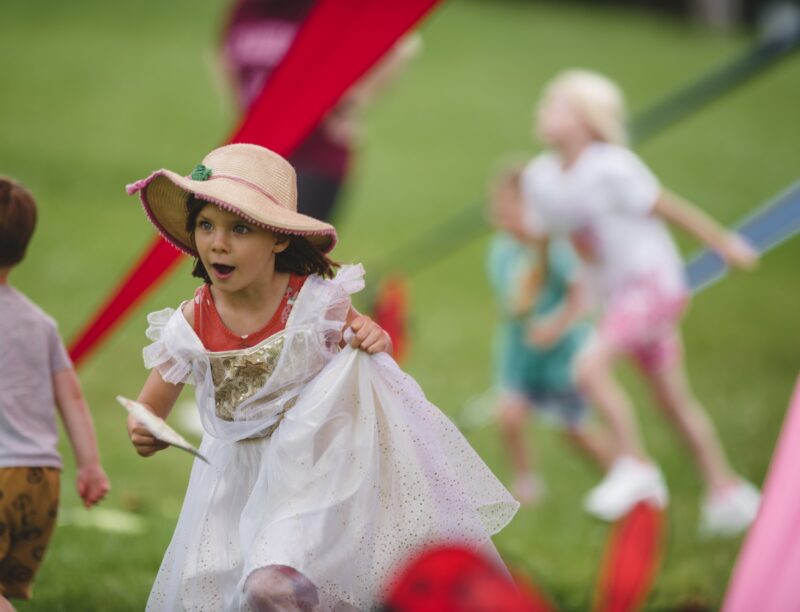 Child in dressing up outfit playing at Killerton