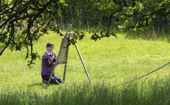 Artist painting in a field
