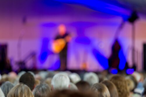 Audience listening to musicians play at a concert at RHS Garden Rosemoor.