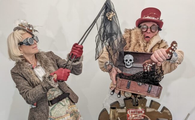 a man and woman in steampunk outfits opening a pirate's chest