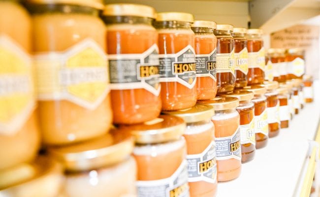 Pots of locally made honey, stacked on a shelf