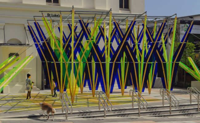 A blue and green public artwork in a public sqaure