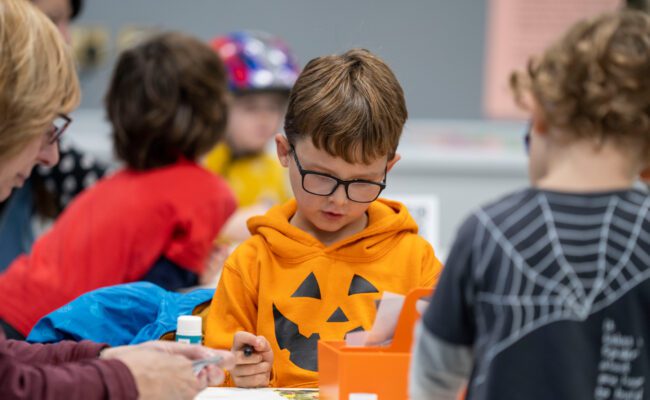 A young boy dressed in an orange top