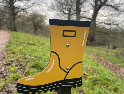 Yellow wellington boot sign acting as a waymarker