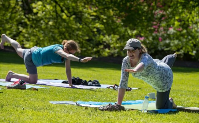 Two women in the garden at Killerton practicing yoga.