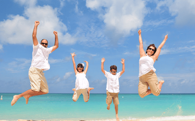 Family jumping in the air on a Devon beach