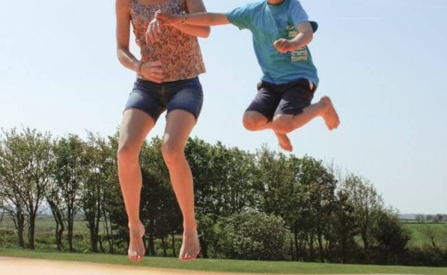 Family bouncing on large bouncy pillow