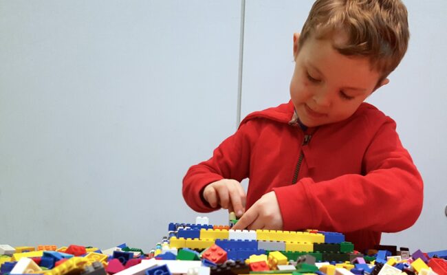 Child playing and building using LEGO®