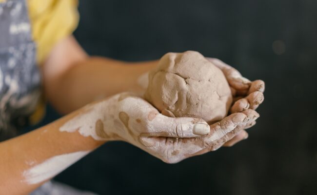 a person holding a ball of clay in their hands