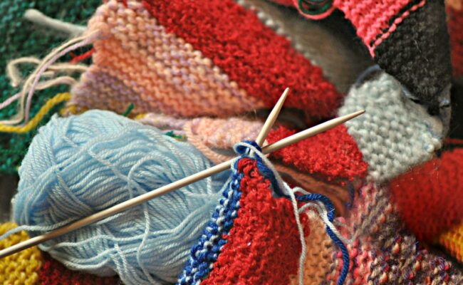 Knitted item, wooden knitting needles and blue wool
